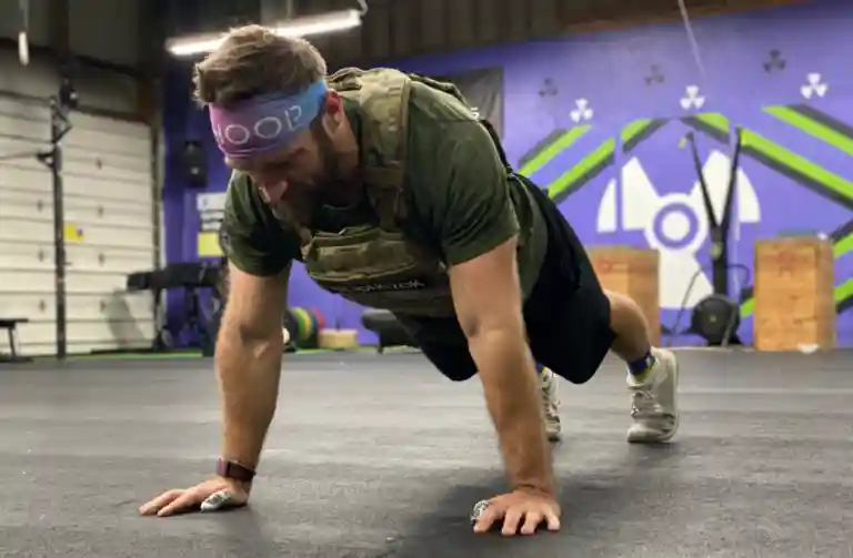 Dr. Alex Hajduczok does a pushup wearing a 20-pound vest as part of a Murph workout.